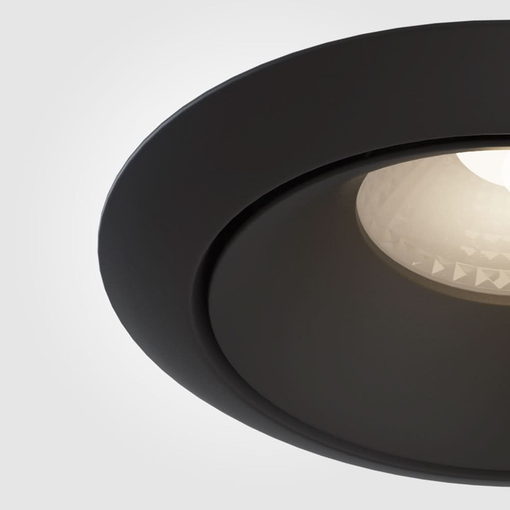 Gros plan sur la bague noire mate et le réflecteur strié du spot