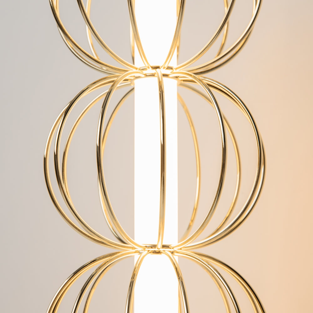 Détail rapproché des cercles métalliques dorés et du tube lumineux central