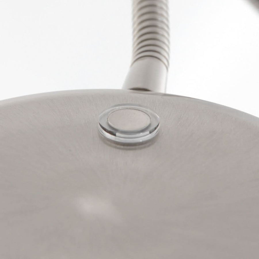Détail du dessus de la tête, bouton poussoir et finition brossée du métal.