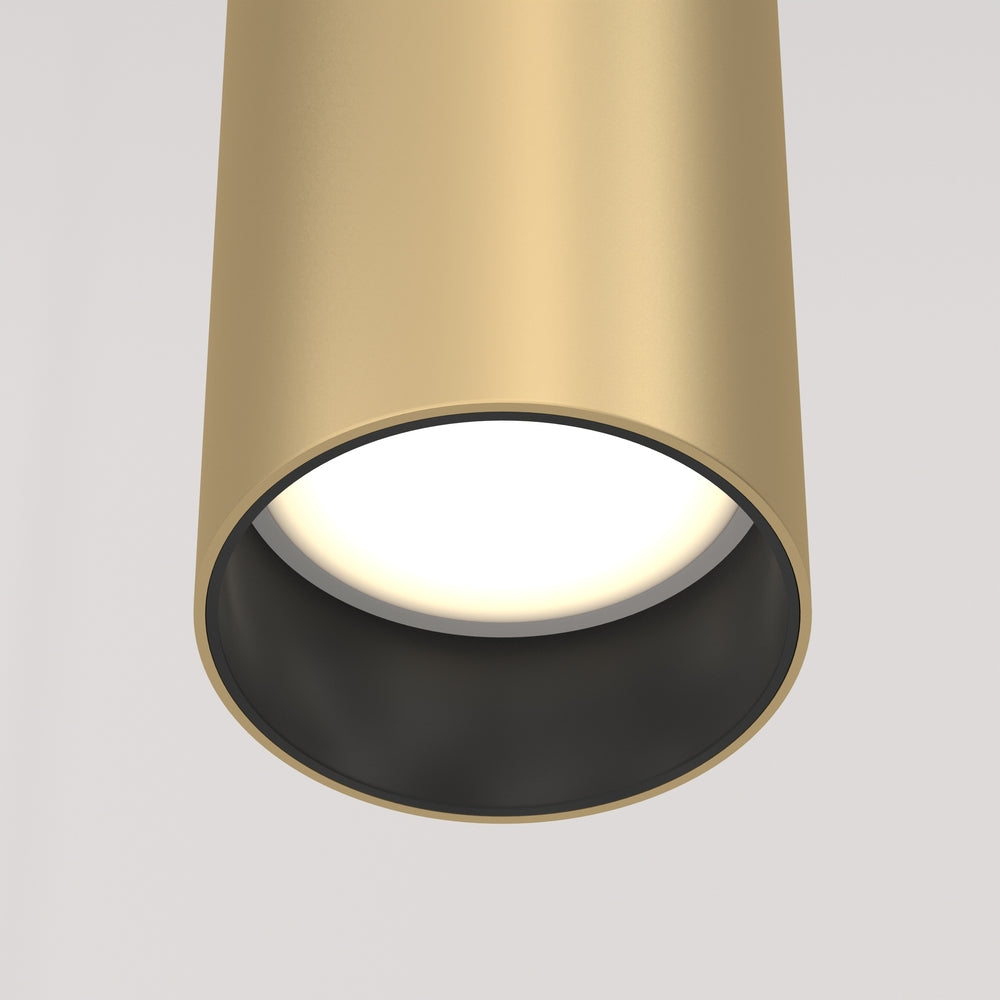 Détail du bas du cylindre doré, diffuseur blanc et intérieur noir mat.