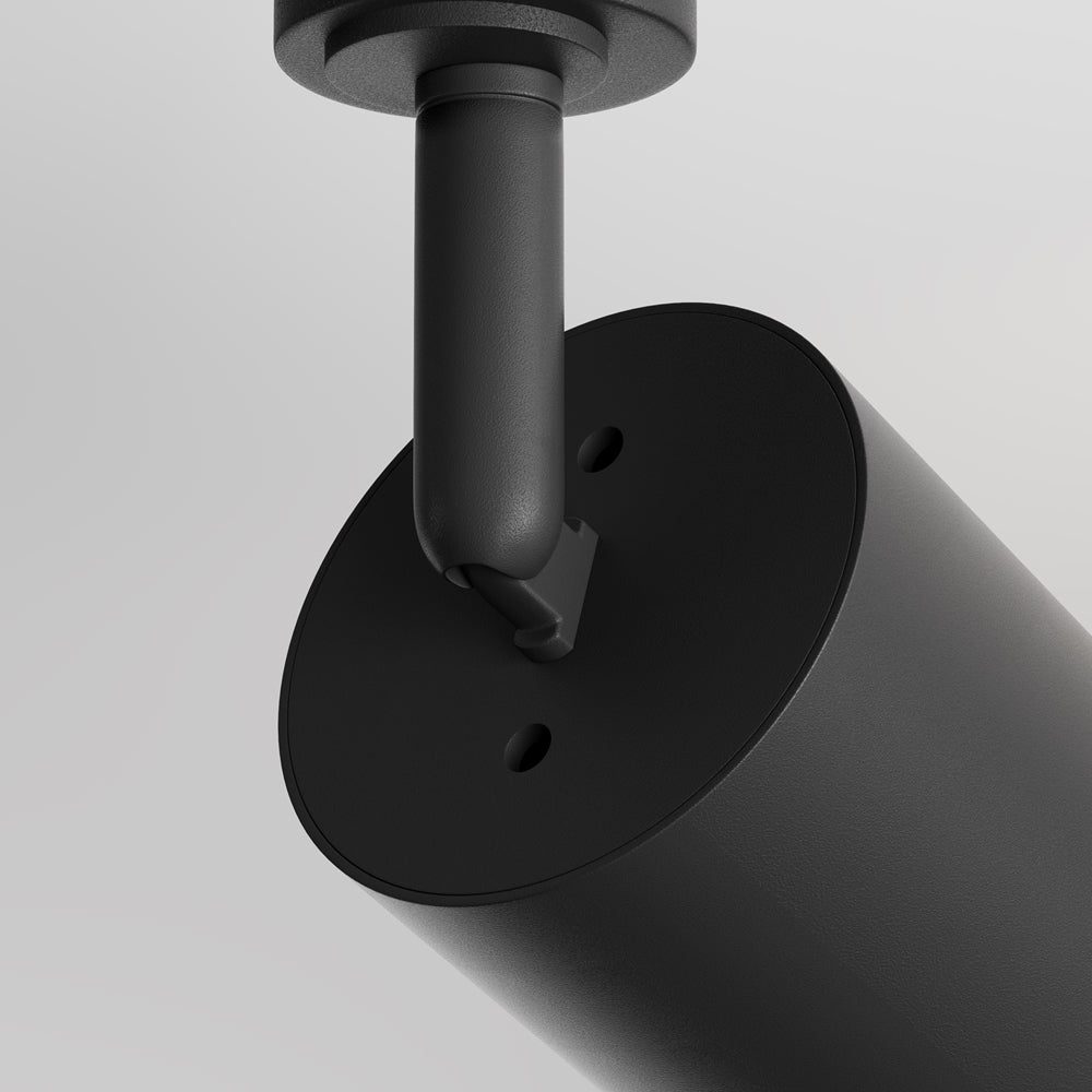 Détail du raccord entre la tige articulée et le corps cylindrique noir mat.