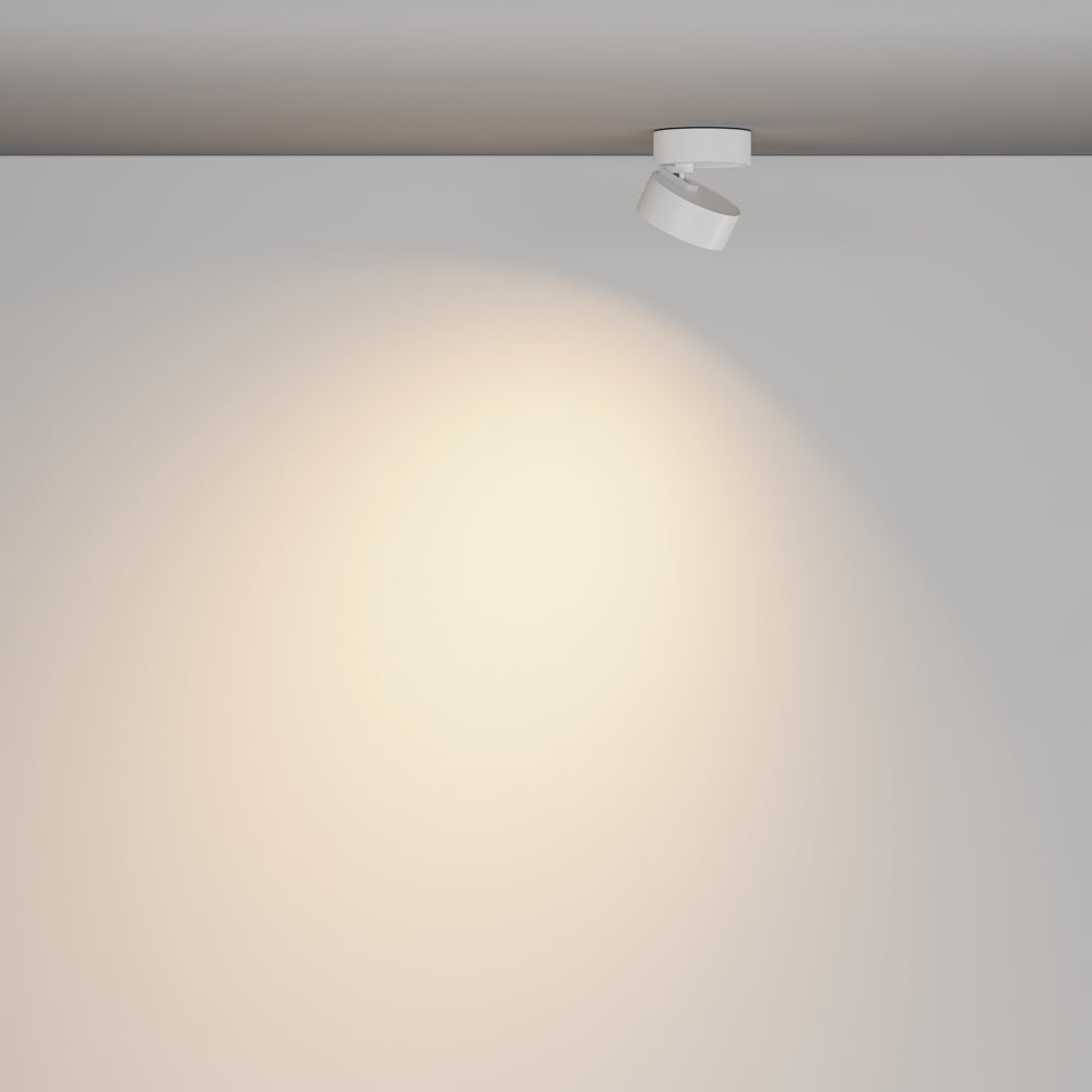 Mise en ambiance, luminaire blanc au plafond éclairant un mur clair