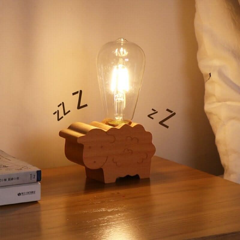 Lampe animalière en bois allumée sur une table de chevet, à côté de livres et d'un lit.