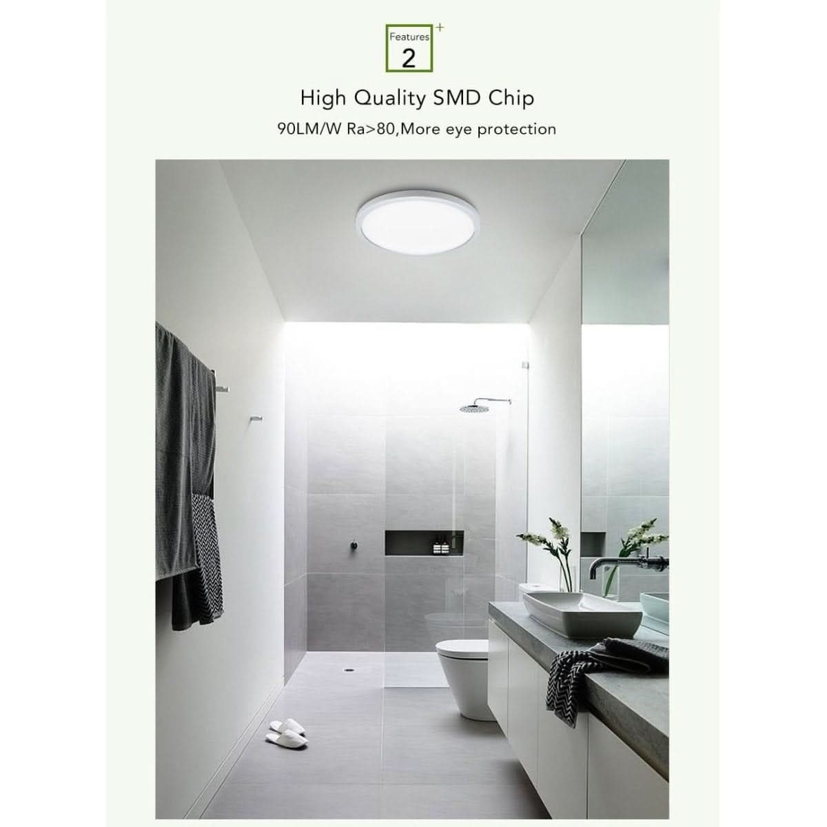 Salle de bain carrelée claire éclairée par le plafonnier rond fixé au plafond