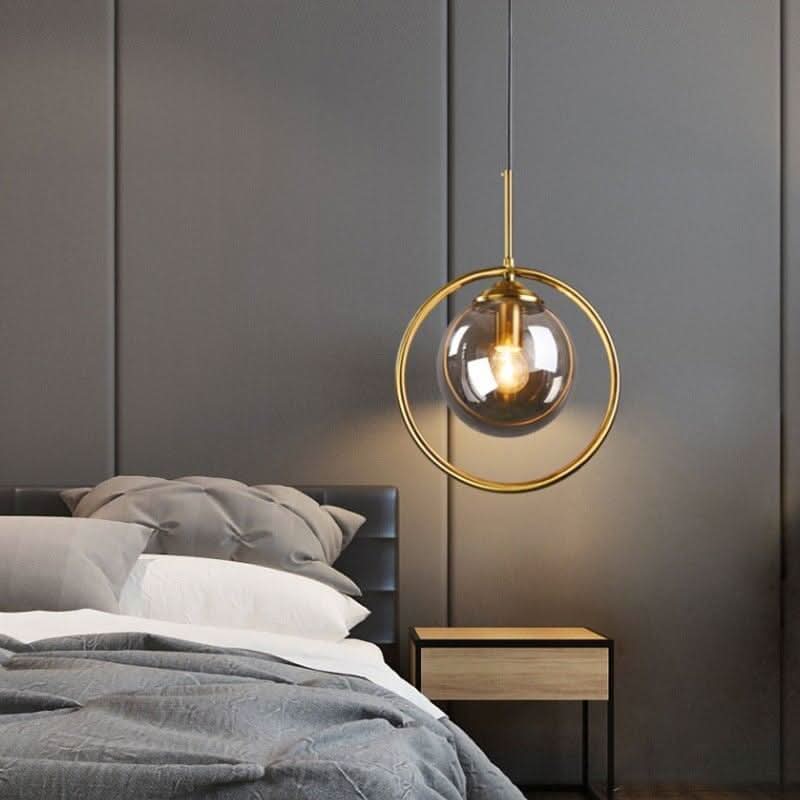 Chambre grise, sphère dorée allumée au-dessus du lit et chevet bois
